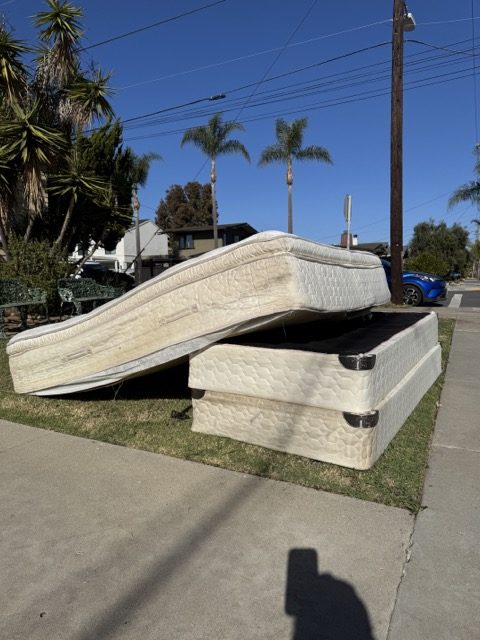 Mattress and box springs on a San Diego parkway waiting for pickup
