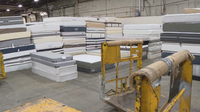 Stacked mattresses waiting to be recycled in a warehouse